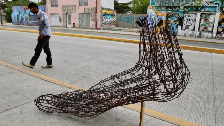 Una escultura hecha con vallas del muro fronterizo honra a migrantes en el norte de México