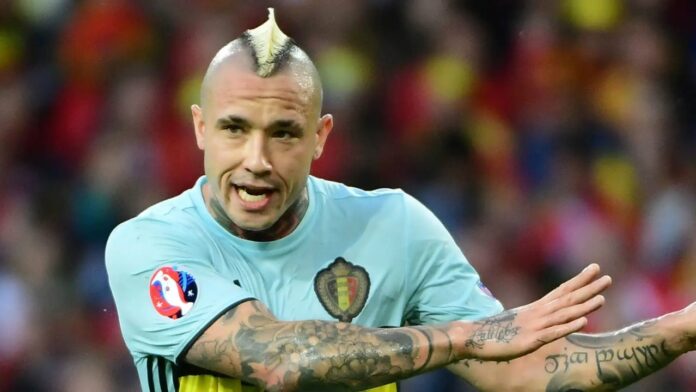 El jugador internacional belga Radja Nainggolan, a punto de cumplir 38 años y aún en activo en el Patro Eisden, deberá comparecer ante un tribunal correccional en el marco de un caso de blanqueo de capitales vinculado a una red de tráfico internacional de cocaína que operaba a través del puerto de Amberes (norte). La Fiscalía de Bruselas acusa al futbolista de haber ocultado el origen ilícito de fondos o haber participado en su transferencia, en una causa en la que también están implicadas otras quince personas. La investigación se centra en la importación de cocaína desde Sudamérica y su posterior distribución en Bélgica. Nainggolan fue detenido a finales de enero de 2025 junto a otros sospechosos en una operación policial que incluyó una treintena de registros y en la que se confiscaron drogas, armas, dinero en efectivo y artículos de lujo. En total, se decomisaron 2,7 kilos de cocaína y unos 370.000 euros. El exjugador del Roma y del Inter de Milán nunca ha sido señalado como participante directo en el tráfico de estupefacientes, pero los investigadores detectaron movimientos financieros sospechosos, entre ellos la recepción de más de 100.000 euros en pocos meses procedentes de Nasr-Eddine Sekkaki, hermano de un conocido criminal y uno de los principales implicados en la trama. El propio jugador ha defendido que ese dinero corresponde a un préstamo que solicitó en un momento de dificultades personales, cuando sus cuentas bancarias estaban bloqueadas tras su divorcio. Según su versión, necesitaba liquidez para hacer frente a deudas, entre ellas algunas derivadas de su afición al juego. Nainggolan, que se enfrenta a una posible pena de hasta cinco años de prisión, ha negado haber blanqueado dinero. EFE